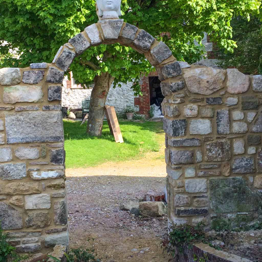 Stone wall with a rustic arched gateway