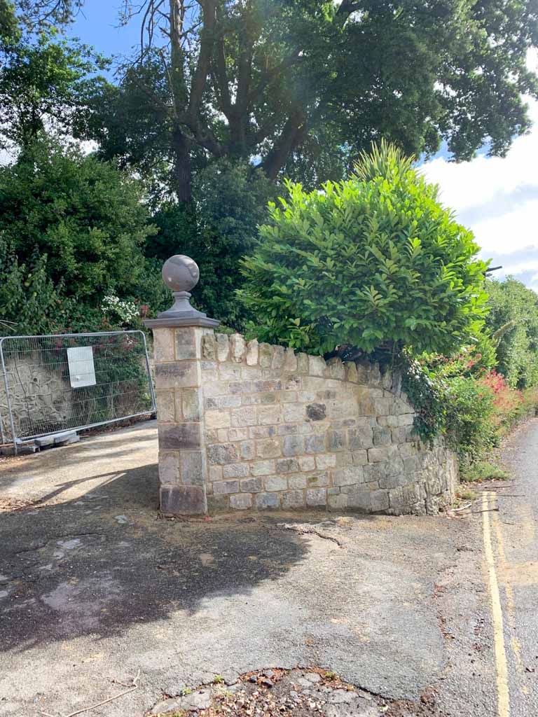 Curved stone garden wall with a decorative ball finial