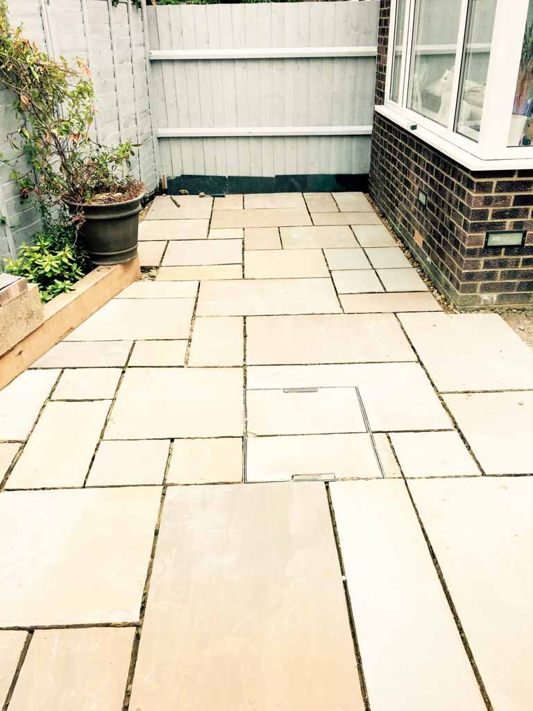 Paved patio beside a brick house