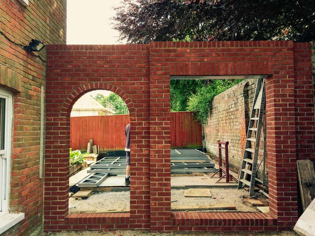 Red brick wall with arched and rectangular openings