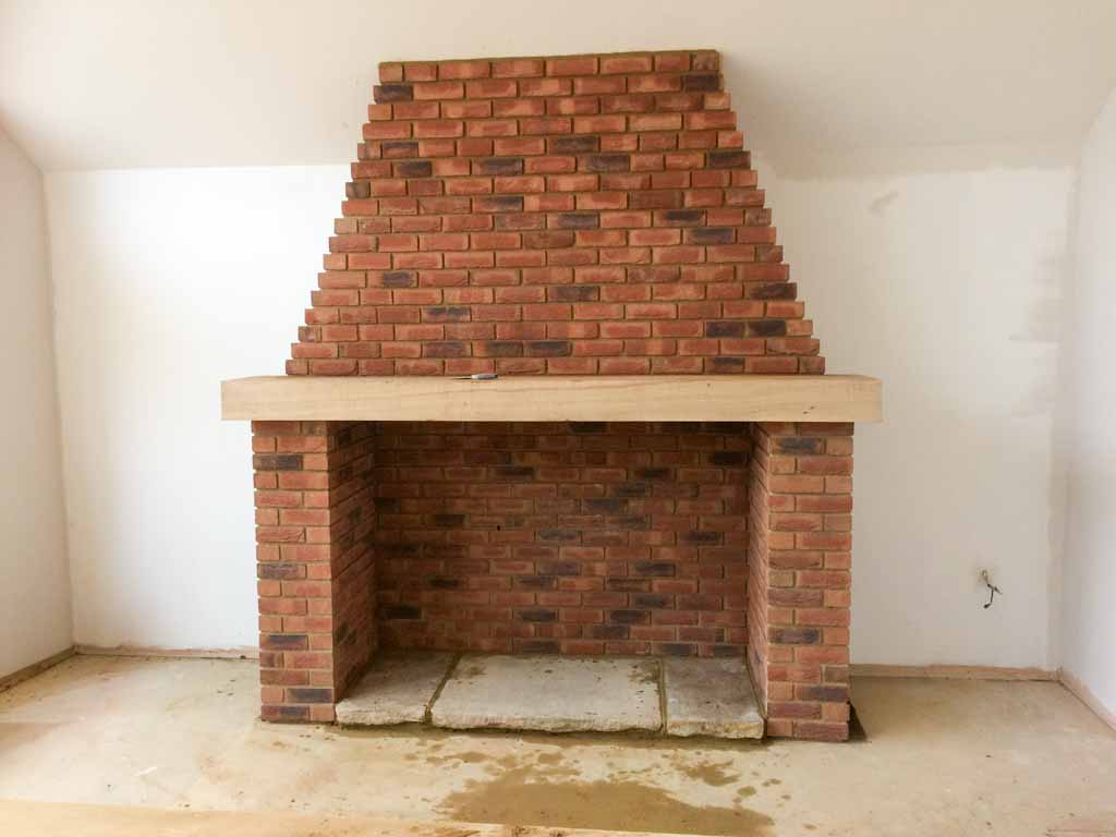 Completed brick fireplace in a newly renovated room