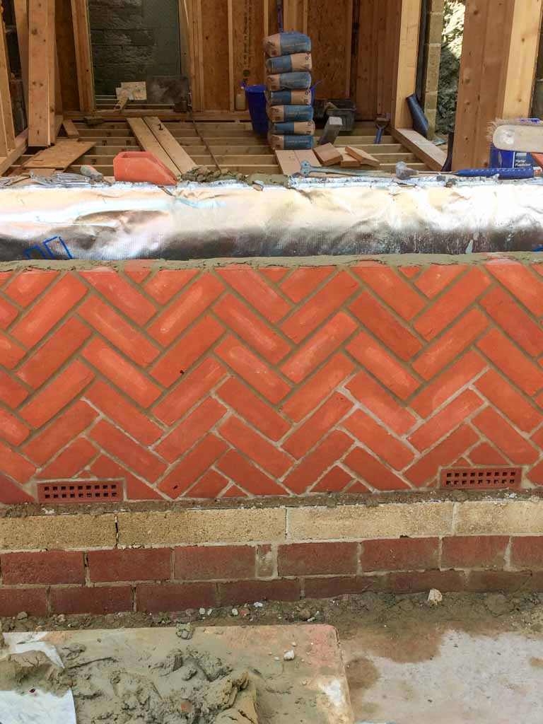 Decorative herringbone brickwork on a garden wall