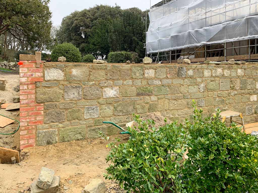 Newly built stone garden wall with brick pillar